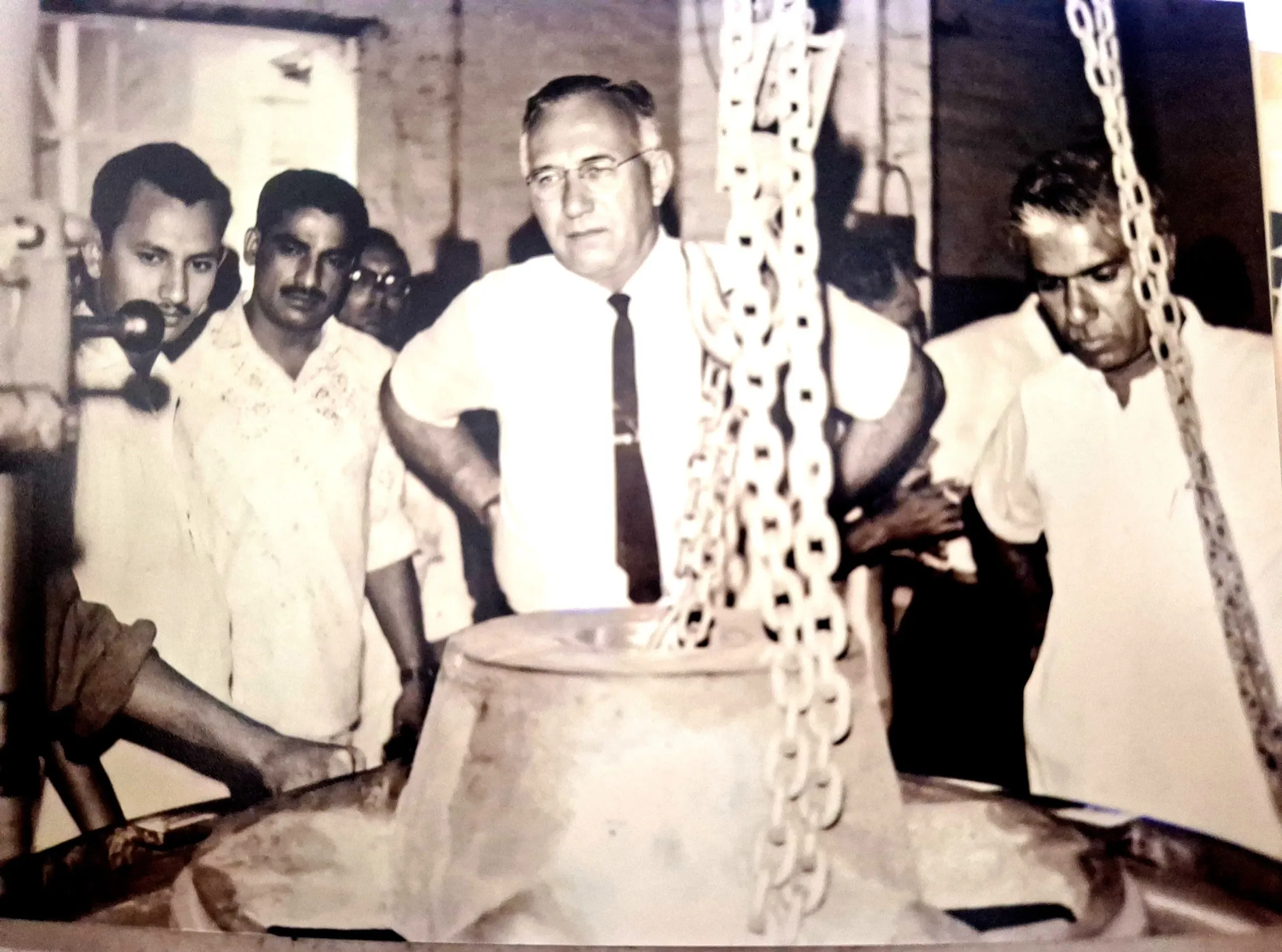 A large parboiling vessel with heavy hoist chains hanging over it.